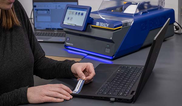 En medarbejder påfører et asset tag (id-tag).