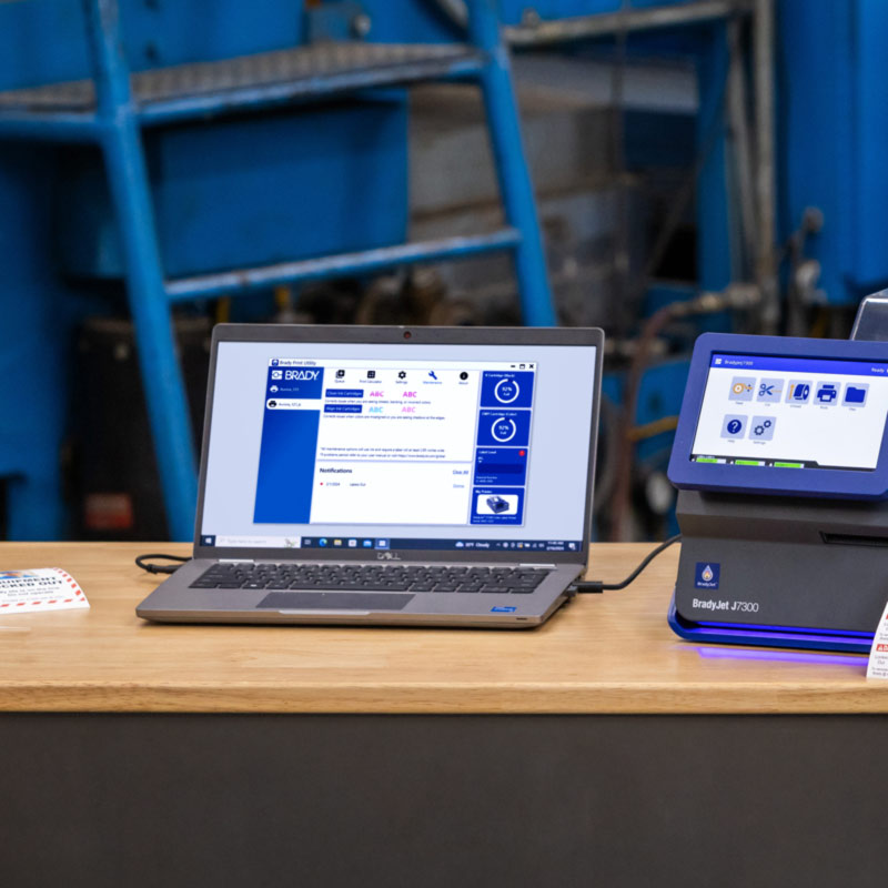 En bærbar computer, der er tilsluttet en J7300, viser en skærm fra en Brady Workstation.