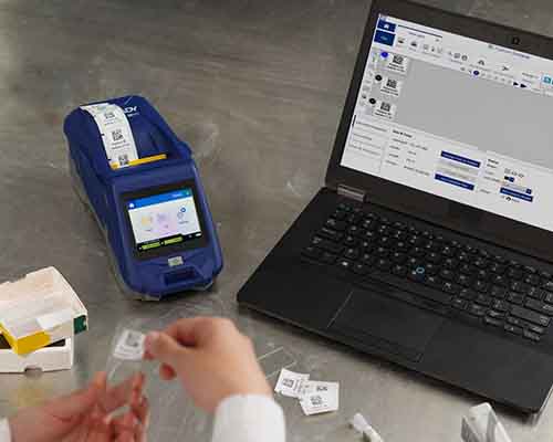 En person sætter en label fra en M611-printer på et objektglas.