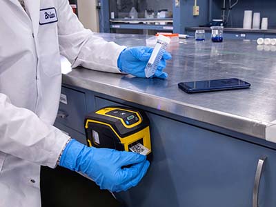 En M211-labelprinter er praktisk tilknyttet en laboratoriearbejdsstation.