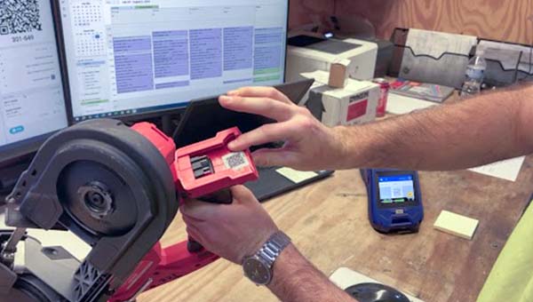 En person peger på en label på et værktøj.